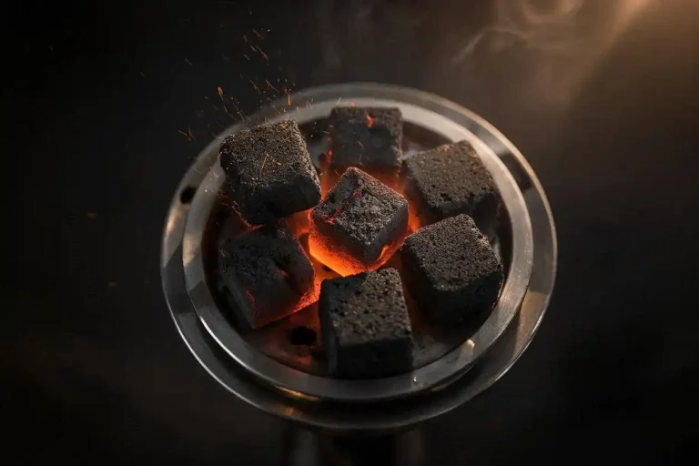 high efficiency charcoal cube fuel glowing on a hookah heat management device with warm ember light