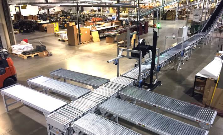 Perbedaan pemindahan barang manual dan conveyor otomatis dalam proses pengangkutan barang di gudang.